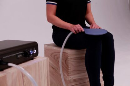Woman applies Paddle Applicator to her knee for PEMF Therapy