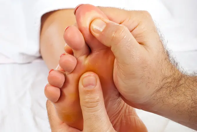 Chiropractor massaging the foot of a women