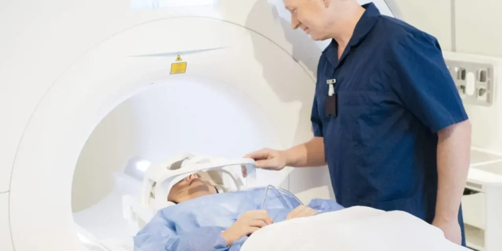 Women goes into MRI machine as a doctor stands by her side