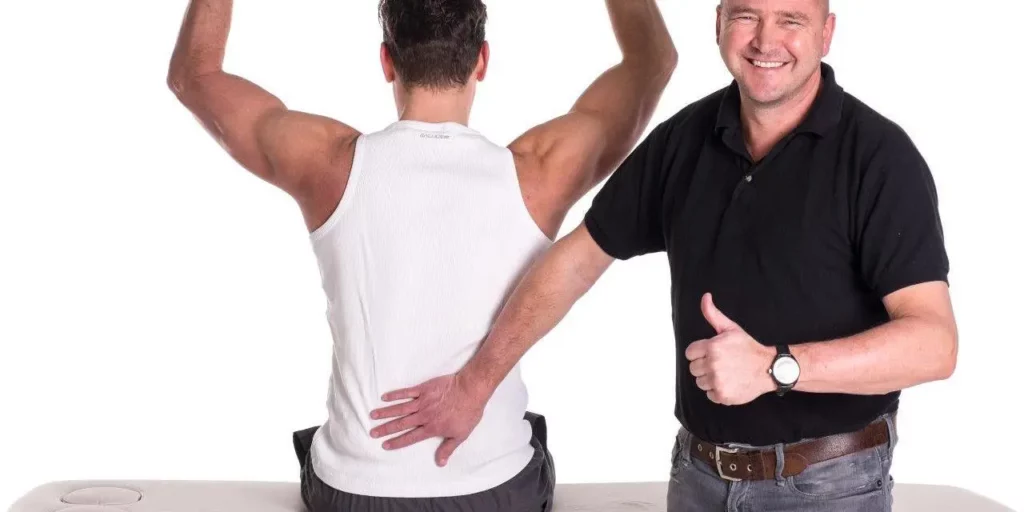 Man holds a thumbs up while another man works out and prevents injuries