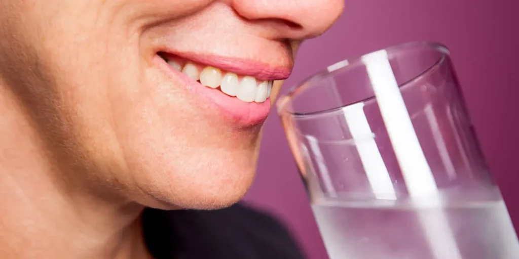 Women smiles and drinks water
