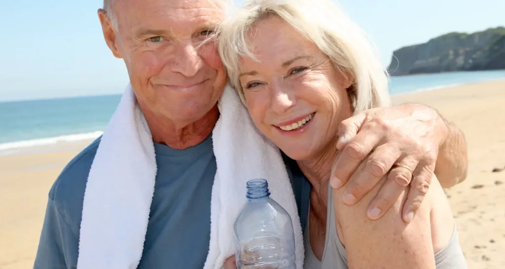 Older couple on beach smiling