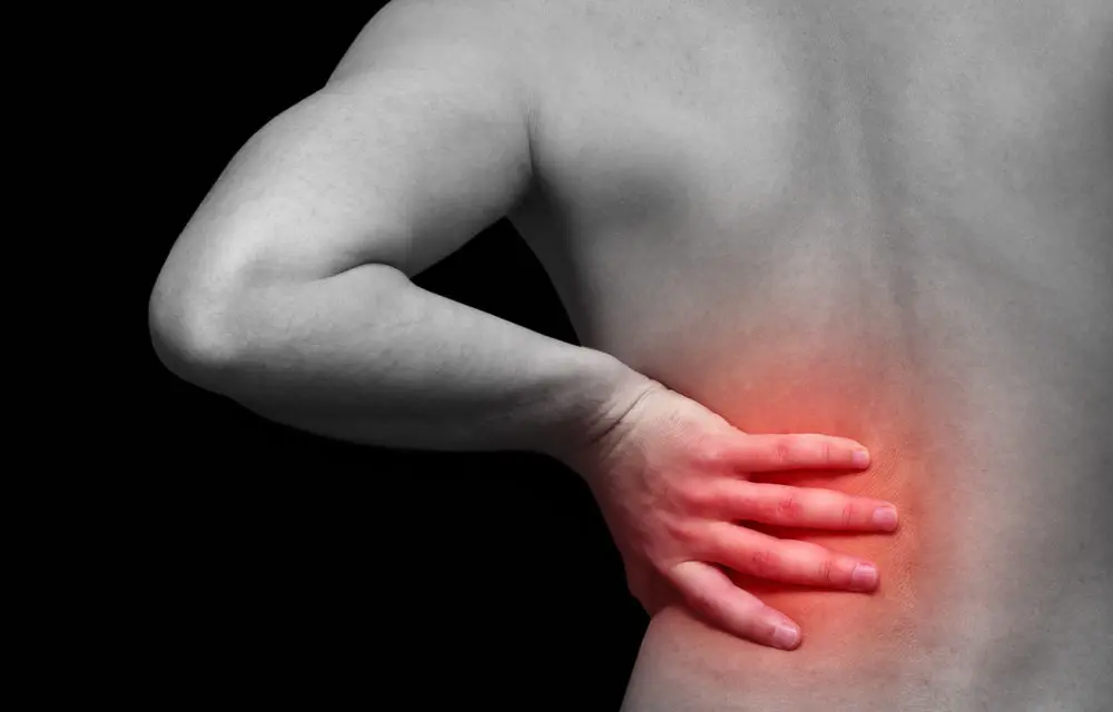 Man holding his back in pain with an area shaded red in the lower back (Photo 2)