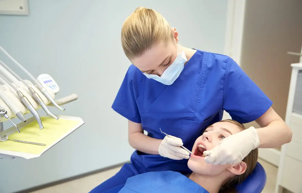 Dentist looks into the mouth of another patient