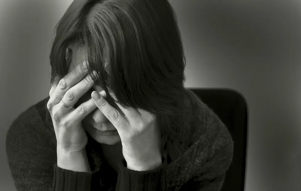 Women holds her face in a state of depression and anxiety